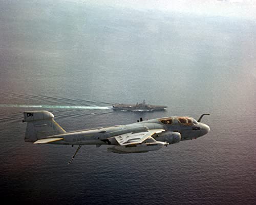 A Tactical Electronic Warfare Squadron 136 (VAQ-136) EA-6B Prowler aircraft flies past the aircraft carrier USS MIDWAY (CV-41) - 20 Inch by 30 Inch Laminated Poster - Bright Colors And Vivid Imagery